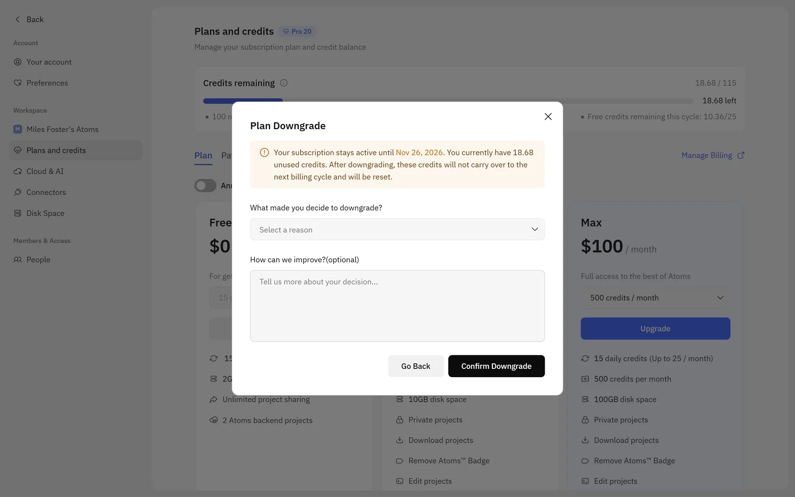 Atoms Plans and credits page with the Plan Downgrade dialog open: the subscription stays active until Nov 26, 2026, 18.68 unused credits will be reset, with a reason box and Go Back and Confirm Downgrade buttons